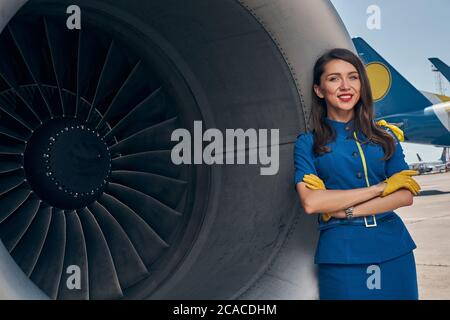 Lächelnder Fluggesellschaftsmitarbeiter, der für die Kamera posiert Stockfoto