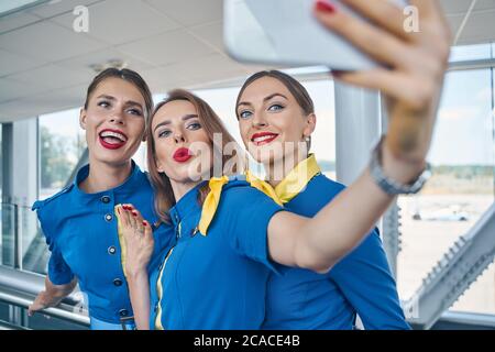 Drei hübsche Damen, die am Flughafen Selfies machen Stockfoto