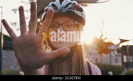 Portraitaufnahme einer jungen Frau mit einem Schutzhelm, Skater, eine Hand vor der Kamera haltend. Hochwertige Fotos Stockfoto