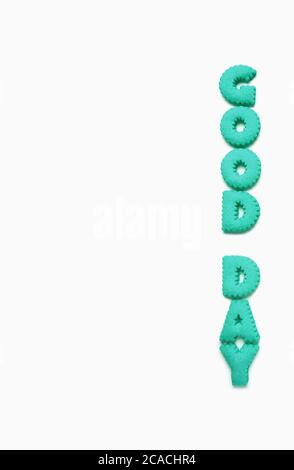 Text des GUTEN TAGES geschrieben mit aquabluem Alphabet geformten Cookies auf weißem Hintergrund Stockfoto