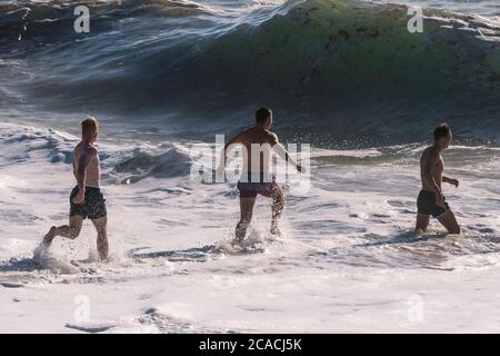 Junge männliche Urlauber verbringen ihren Urlaub am Fistral Beach in Newquay in Cornwall. Stockfoto