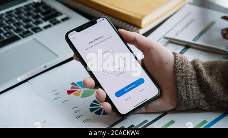 CHIANG MAI, THAILAND - APR 11, 2020 : EIN Mitarbeiter von zu Hause aus ist der Download der Zoom-Anwendung Social Platform, bereit für Internet-Meetings Stockfoto