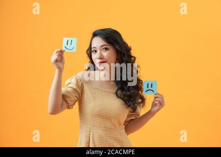 Foto von lustigen Dame halten Papier Emoticons gute und schlechte Laune Kommissionierung positive Emotionen Stockfoto