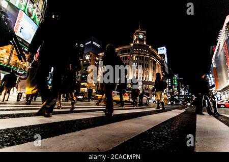 Tokyo, Japan - 14. Januar 2010: Fußgänger überqueren der Straße im Herzen von Ginza in Tokio. Ginza Kreuzung bei Nacht. Verschwommene Bewegung. Stockfoto