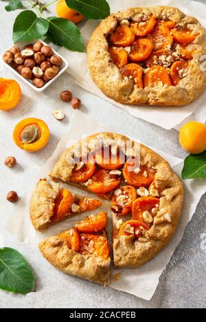 Gesundes Gebäck aus Roggenmehl, Dessert Diät-Essen. Galette mit Aprikosen und Nüssen auf einem hellen Steintisch. Stockfoto