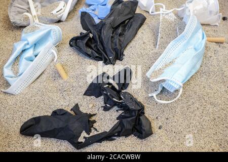 Gesichtsmasken, Handschuhe und Plastikmüll, medizinische Einweg-Müll an der Küste, kovid Meeresverschmutzung Stockfoto