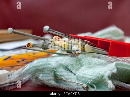 Stricknadeln bereit für die Aktion auf einem Stapel Stricken. Stockfoto