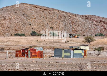 Traditionelle afrikanische Hütte aus rostigen Zinnblech in der Wüste der Erongo Region. Im Hintergrund ist der Brandberg. Namibia Wildnis, dort lebender Peop Stockfoto