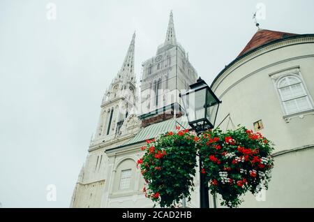 Eine Seitenansicht der Kathedrale von Zagreb aus einem Winkel von unten nach oben und mit einem der Türme unter Wartung in einem bewölkten Nachmittag. Stockfoto