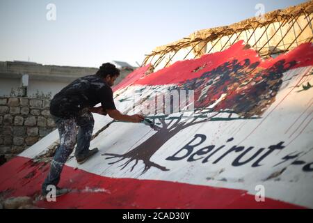 Idlib, Syrien. August 2020. Ein Syrer sah am 6. August 2020 in der Stadt Bennach östlich von Idlib eine libanesische Flagge an den Wänden malen, um die Syrer mit dem libanesischen Volk zu solidarisieren, nachdem der Hafen von Beirut gestern einer gewaltigen Explosion ausgesetzt war, bei der mehr als 100 und 4000 Verletzte getötet wurden. (Foto von Ali Haj Suleiman/INA Photo Agency/Sipa USA) Quelle: SIPA USA/Alamy Live News Stockfoto