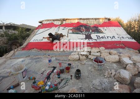 Idlib, Syrien. August 2020. Ein Syrer sah am 6. August 2020 in der Stadt Bennach östlich von Idlib eine libanesische Flagge an den Wänden malen, um die Syrer mit dem libanesischen Volk zu solidarisieren, nachdem der Hafen von Beirut gestern einer gewaltigen Explosion ausgesetzt war, bei der mehr als 100 und 4000 Verletzte getötet wurden. (Foto von Ali Haj Suleiman/INA Photo Agency/Sipa USA) Quelle: SIPA USA/Alamy Live News Stockfoto