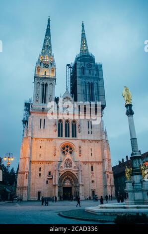 Eine Vorderansicht der Kathedrale von Zagreb aus einem Winkel von unten nach oben und mit einem der Türme unter Wartung in einem bewölkten Nachmittag. Stockfoto