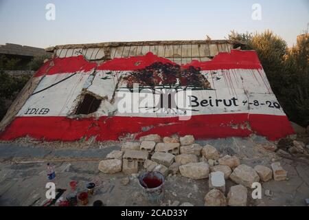 Idlib, Syrien. August 2020. Ein Syrer sah am 6. August 2020 in der Stadt Bennach östlich von Idlib eine libanesische Flagge an den Wänden malen, um die Syrer mit dem libanesischen Volk zu solidarisieren, nachdem der Hafen von Beirut gestern einer gewaltigen Explosion ausgesetzt war, bei der mehr als 100 und 4000 Verletzte getötet wurden. (Foto von Ali Haj Suleiman/INA Photo Agency/Sipa USA) Quelle: SIPA USA/Alamy Live News Stockfoto