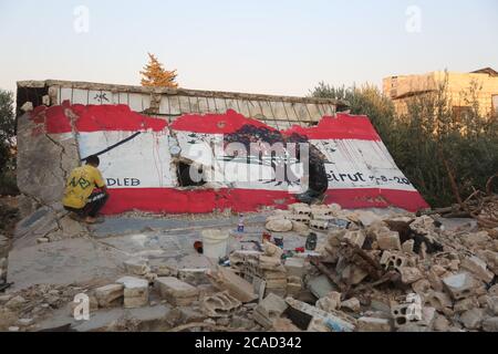 Idlib, Syrien. August 2020. Ein Syrer sah am 6. August 2020 in der Stadt Bennach östlich von Idlib eine libanesische Flagge an den Wänden malen, um die Syrer mit dem libanesischen Volk zu solidarisieren, nachdem der Hafen von Beirut gestern einer gewaltigen Explosion ausgesetzt war, bei der mehr als 100 und 4000 Verletzte getötet wurden. (Foto von Ali Haj Suleiman/INA Photo Agency/Sipa USA) Quelle: SIPA USA/Alamy Live News Stockfoto