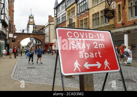 Ein COVID 19-Schild im Stadtzentrum von Chester erinnert die Leute daran, 2 Meter voneinander entfernt zu bleiben Stockfoto