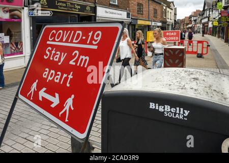 Ein COVID 19-Schild im Stadtzentrum von Chester erinnert die Leute daran, 2 Meter voneinander entfernt zu bleiben Stockfoto