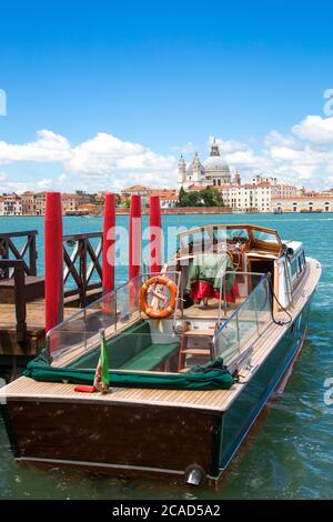 Boot am Pier festgemacht. Im Hintergrund der Kathedrale Santa Maria della Salute. Venedig, Italien. Nahaufnahme. Stockfoto