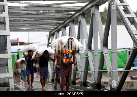 Yangon, Myanmar. August 2020. Arbeiter tragen Reissäcke an einem Steg in Yangon, Myanmar, 6. August 2020. Myanmar exportierte über 2.25 Millionen Tonnen Reis und gebrochenen Reis ab Juli 17 in diesem Geschäftsjahr (GJ) 2019-2020, nach einer Pressemitteilung der Myanmar Rice Federation am Mittwoch. Quelle: U Aung/Xinhua/Alamy Live News Stockfoto