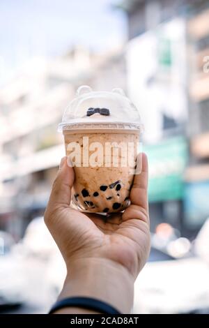 Bubble Ball Eis Milch Tee in der Hand mit Blur Asia Gebäude Hintergrund. Stockfoto