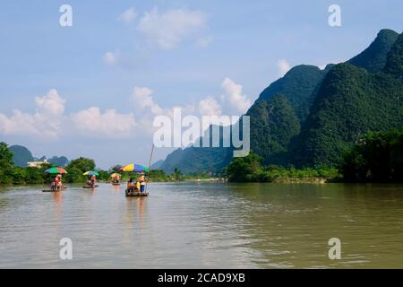 Mehrere Bambusflöße auf friedlichem Fluss schwimmen. Perspektivisch grüne Berge. In Yangshuo Guilin China. Karstlandform Stockfoto