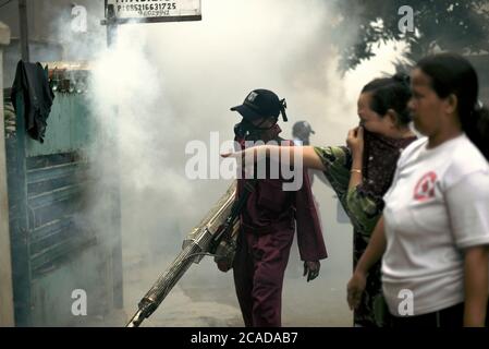 Beamte des örtlichen Gesundheitsamtes, die Insektizid-Beschlagssitzung durchführen, eine Dengue-Fieber-Ausbruchsprävention in einem dicht besiedelten Gebiet von Jakarta. Stockfoto