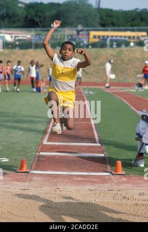 Austin Texas USA: Junger afroamerikanischer Junge tritt beim Weitsprung-Event während des Sommerliga-Track-and-Field-Meetings an. ©Bob Daemmrich Stockfoto