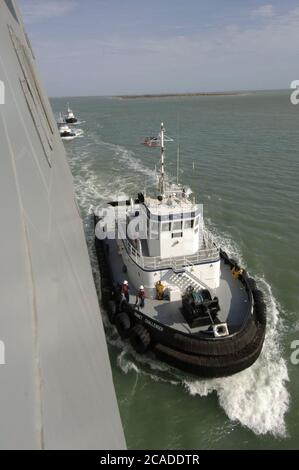 Port Aransas, Texas USA, 15. Januar 2006: Jungfernfahrt der USS San Antonio (LPD-17) Amphibiendock nach ihrer Inbetriebnahme am Vortag. Kommerzielle Schlepper manövrieren um die USS San Antonio, um sie in den Hafen zu bringen. ©Bob Daemmrich Stockfoto