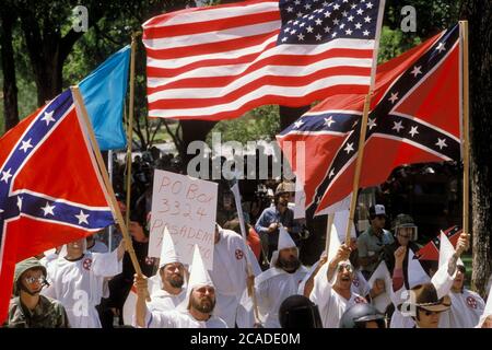 Austin Texas USA, um 1984: Ku Klux Klan-Mitglieder mit konföderierten und amerikanischen Flaggen, die sich in der Innenstadt in der Nähe des Texas Capitol tummeln. ©Bob Daemmrich Stockfoto