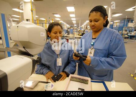 Matamoros, Mexiko April 2006: Mexikanische Arbeiter bei CyOptics, einer High-Tech-Produktionsstätte direkt gegenüber der US-Grenze von Brownsville, Texas. CyOptics, ein Unternehmen im Besitz der USA, entwirft, entwickelt und vermarktet eine Reihe von optischen Chips und Komponenten für die Integration in Zugangssysteme, Metro- und Fernkommunikationssysteme. Darüber hinaus bietet das Unternehmen Dienstleistungen in den Bereichen Vertragsgestaltung, Fertigung und Verpackung an. ©Bob Daemmrich Stockfoto