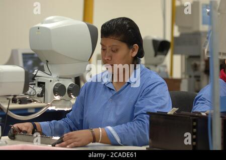 Matamoros, Mexiko April 2006: Mexikanische Arbeiter bei CyOptics, einer High-Tech-Produktionsstätte direkt gegenüber der US-Grenze von Brownsville, Texas. CyOptics, ein Unternehmen im Besitz der USA, entwirft, entwickelt und vermarktet eine Reihe von optischen Chips und Komponenten für die Integration in Zugangssysteme, Metro- und Fernkommunikationssysteme. Darüber hinaus bietet das Unternehmen Dienstleistungen in den Bereichen Vertragsgestaltung, Fertigung und Verpackung an. ©Bob Daemmrich Stockfoto