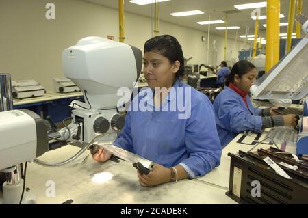 Matamoros, Mexiko April 2006: Mexikanische Arbeiter bei CyOptics, einer High-Tech-Produktionsstätte direkt gegenüber der US-Grenze von Brownsville, Texas. CyOptics, ein Unternehmen im Besitz der USA, entwirft, entwickelt und vermarktet eine Reihe von optischen Chips und Komponenten für die Integration in Zugangssysteme, Metro- und Fernkommunikationssysteme. Darüber hinaus bietet das Unternehmen Dienstleistungen in den Bereichen Vertragsgestaltung, Fertigung und Verpackung an. ©Bob Daemmrich Stockfoto