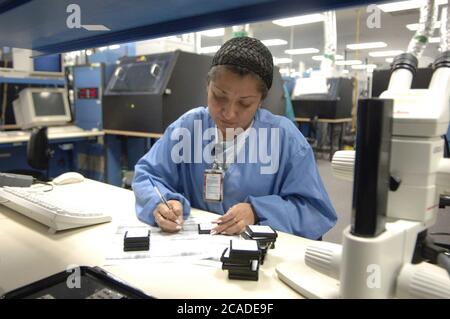 Matamoros, Mexiko April 2006: Mexikanische Arbeiter bei CyOptics, einer High-Tech-Produktionsstätte direkt gegenüber der US-Grenze von Brownsville, Texas. CyOptics, ein Unternehmen im Besitz der USA, entwirft, entwickelt und vermarktet eine Reihe von optischen Chips und Komponenten für die Integration in Zugangssysteme, Metro- und Fernkommunikationssysteme. Darüber hinaus bietet das Unternehmen Dienstleistungen in den Bereichen Vertragsgestaltung, Fertigung und Verpackung an. ©Bob Daemmrich Stockfoto