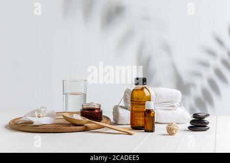 Schöne Spa-Komposition auf Massageliege im Wellness-Center, Copyspace. Zubehör für entspannende Behandlungen und Körperpflege. Handtücher, Öle, Serum, Meersalze und Peelings. Dekorative Kerzen. Stockfoto