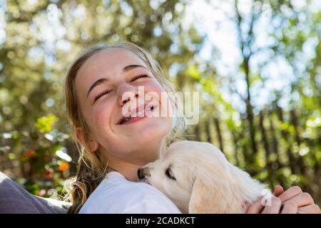 Teen Alter Mädchen hält ein Englisch golden Retriever Welpen Stockfoto