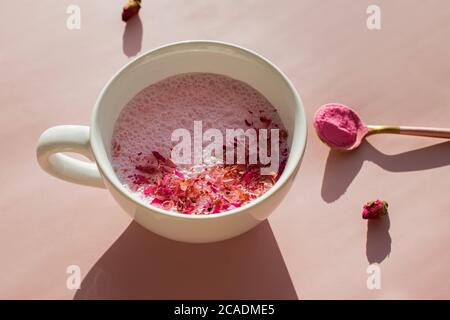 Tasse rosa Kardamom ayuverdic Getränk auf rosa Hintergrund. Stockfoto