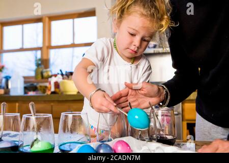 3 Jahre altes Mädchen Färbung ostereier zu Hause mit ihrer Mutter Stockfoto