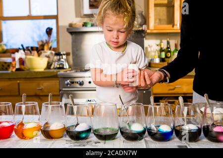 3 Jahre altes Mädchen Färbung ostereier zu Hause mit ihrer Mutter Stockfoto