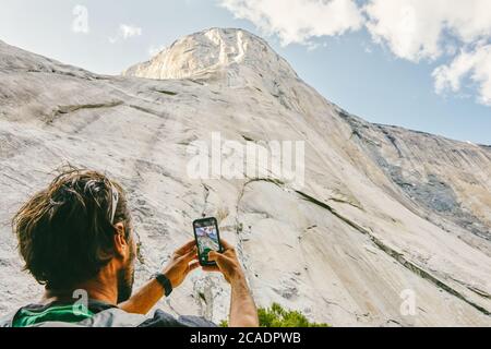 Junger Mann fotografiert den El Capitan Berg im Yosemite Park. Stockfoto