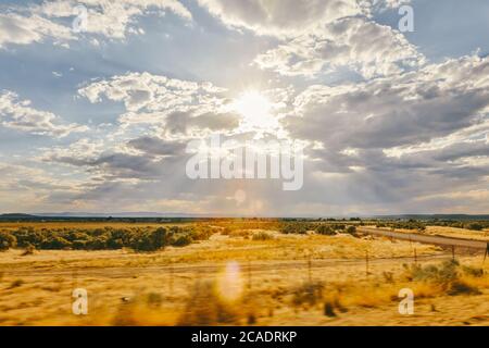 Blick auf einen Sonnenuntergang über dem Feld auf einer Fahrt durch Meadow, Utah. Stockfoto