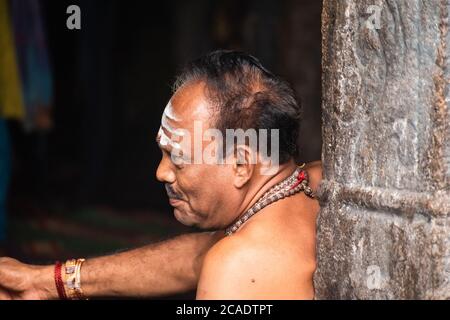 Mayiladuthurai, Tamil Nadu, Indien - Februar 2020: Ein ehrliches Porträt eines hinduistischen Priesters mit heiligem Asche auf der Stirn im alten Tempel Stockfoto