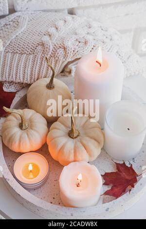 Stillleben im Herbst mit weißen Kürbissen und brennenden Kerzen Stockfoto