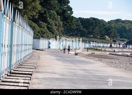 Eine Reihe von bunten Strandhütten in Avon Beach, Mudeford, bei Christchurch, Dorset, Großbritannien Stockfoto