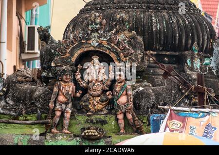 Mayiladuthurai, Tamil Nadu, Indien - Februar 2020: Verblasste Schnitzereien des Hindu-Gottes Ganesha auf dem verwitterten Dach eines Schreins im alten Hindu Stockfoto