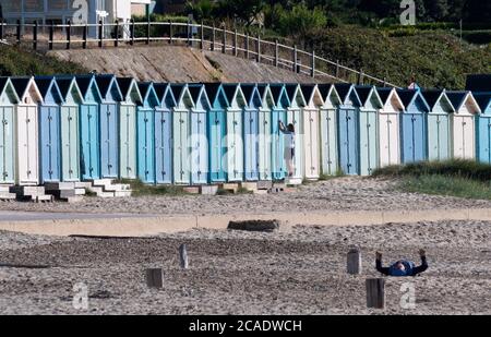 Eine Reihe von bunten Strandhütten in Avon Beach, Mudeford, bei Christchurch, Dorset, Großbritannien Stockfoto