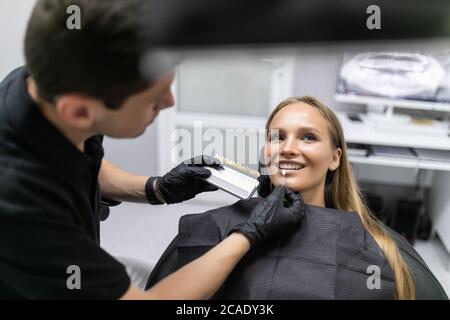 Schöne europäische Frau lächeln mit gesunden Zahnaufhellung. Set von Implantaten mit verschiedenen Schattierungen von Ton Stockfoto