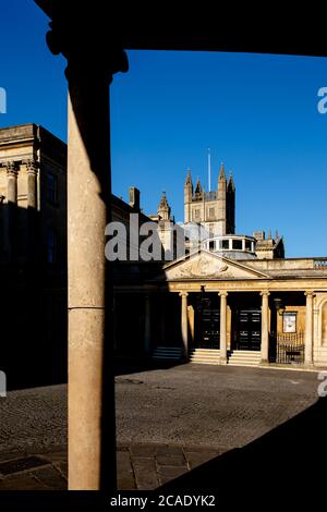 Fassade der römischen Bäder mit Bath Abbey hinter in Bath, England, Großbritannien. Stockfoto