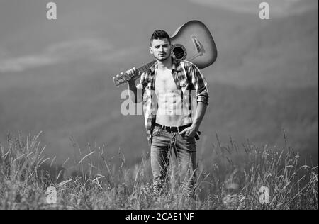 Mann mit Gitarre auf dem Gipfel des Berges. Beste weg von Stadt zu entkommen. Guy Wanderer Natur pur genießen. Ausflüge in die Natur. Schönheit der Natur. Frische Luft der Berge. Ferienhäuser Reiseziele. Allein gehen. Stockfoto