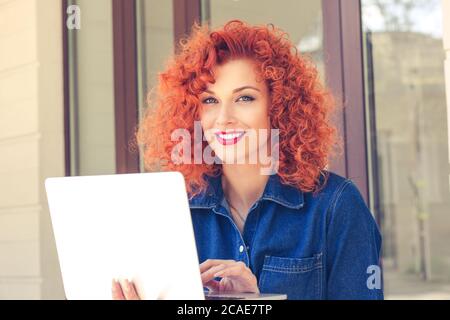 Portrait der jungen Frau, die Kamera mit Laptop-Computer für die Suche nach Informationen und Banking, qualifizierte Freiberuflerin konzentriert sich auf Remote Stockfoto