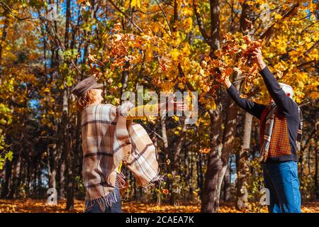 Herbst Jahreszeit. Paar Blätter im Herbst Wald werfen. Senior Familie Spaß im Freien Stockfoto