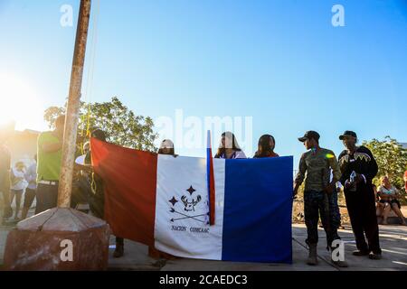 Ceremonia U honores a la badera de la nacion Comcaác o Seri, , durante la celebración del año nuevo Seri en la comunidad indigena Punta Chueca, Sonora Mexiko. Territorio Comcaác está en el desierto y la costa de Sonora y el Golfo de California, se compon de Punta Chueca, Isla del Tiburón y Desemboque pertenecientes a los municipios de Hermosillo y Pitiquito en el estado de Sonora.Tienen cierta autonomía independiente. Los seris habitan principalmente las localidades de El Desemboque (Haxöl Iihom, municipio de Pitiquito, y Punta Chueca (Socaaix) en la costa. Cultura tradicional, Ahnen, usos Stockfoto